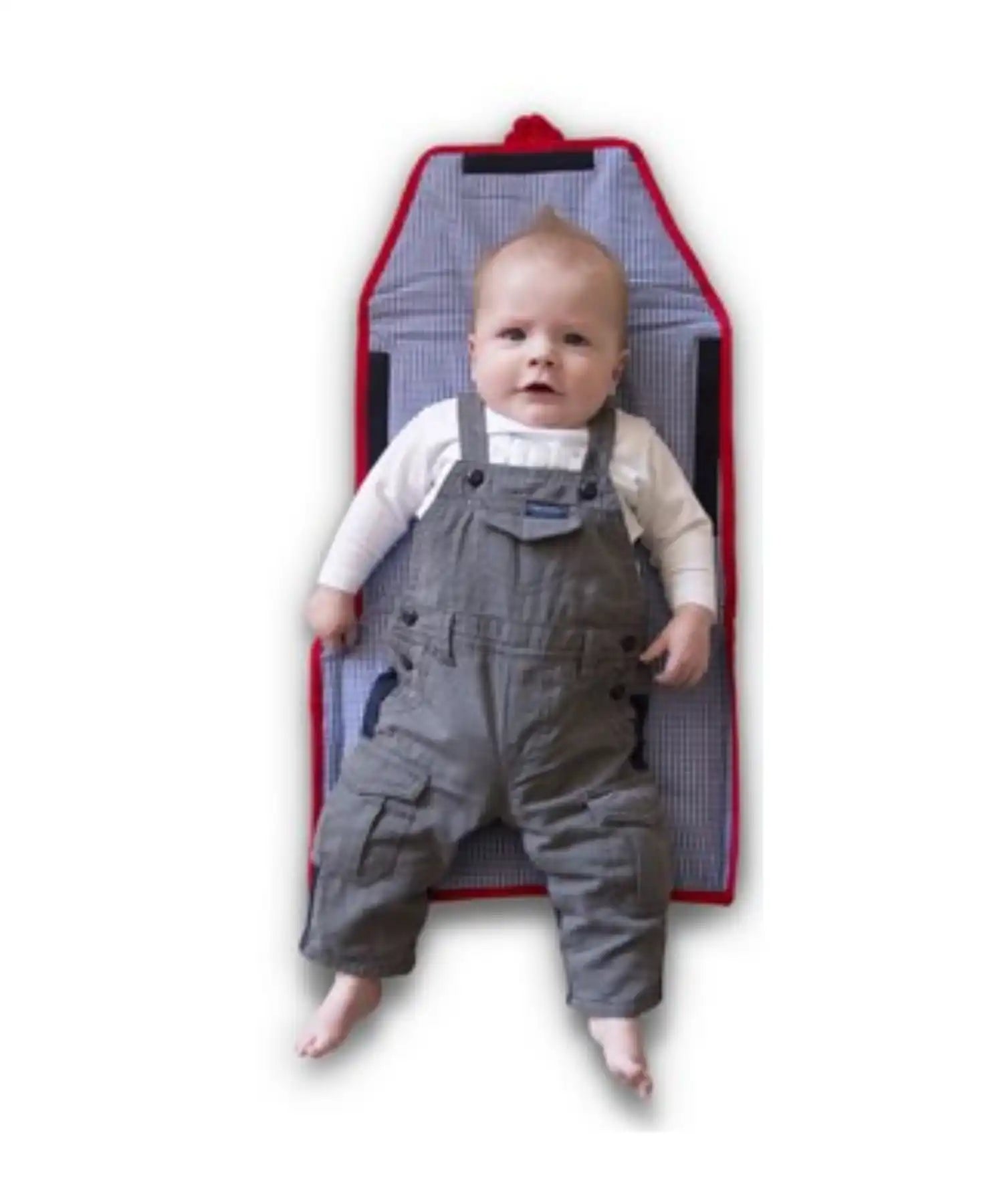 Een baby die grijze broekjes en een wit lang mouwen shirtje draagt, liggend op een blauwe en witte gestreepte verschoningsmat met rode rand.