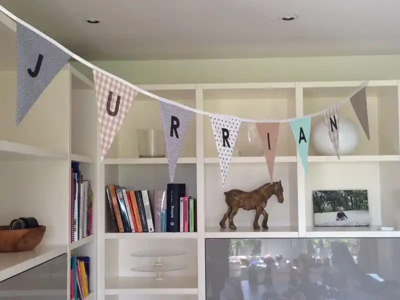 Een decoratief stoffen banner met individuele letter pennants.