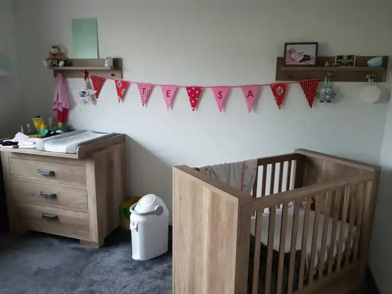 Een houten wieg en verschoningskussen set.