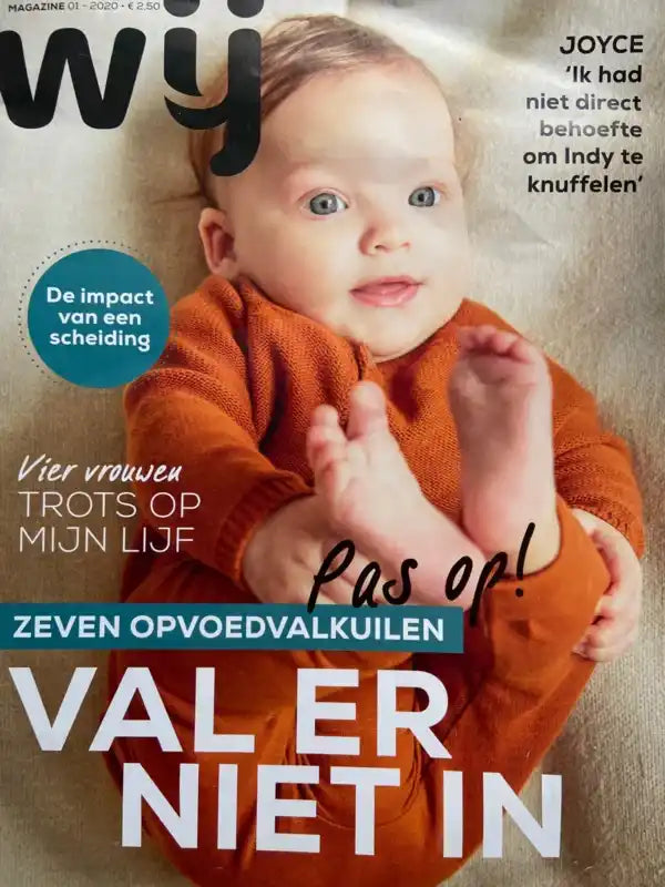 Een tijdschriftomslag met een baby in een oranje outfit, met tekstoverlays over verschillende onderwerpen.