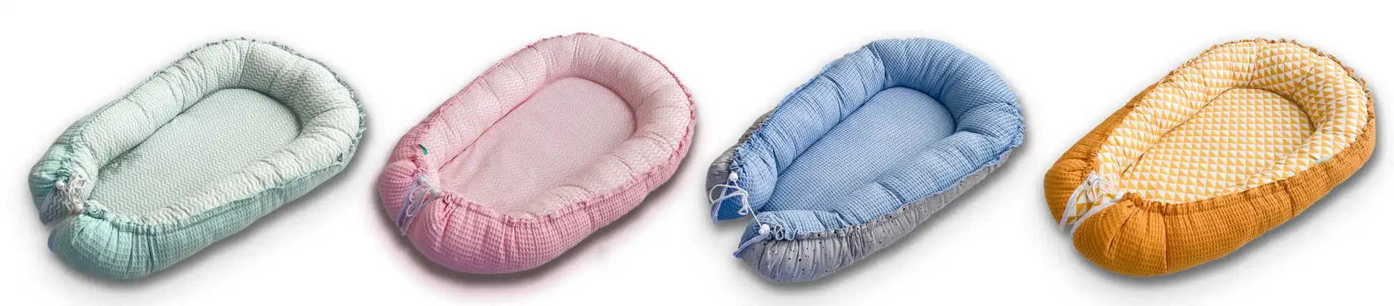 Vier zachte, draagbare wiegen voor baby's in verschillende pastelkleuren.